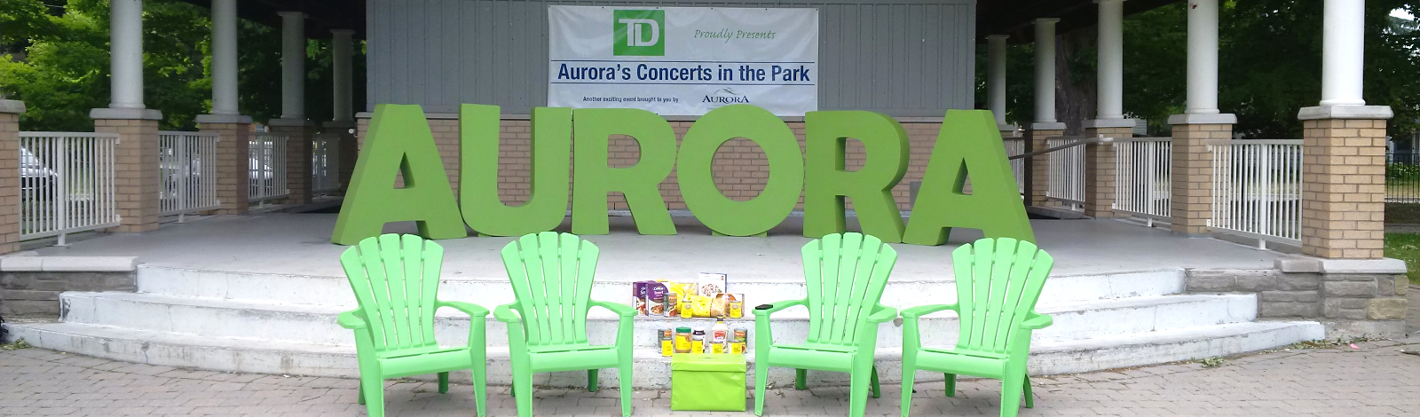 Concerts in the park stage with AURORA letters and green chairs