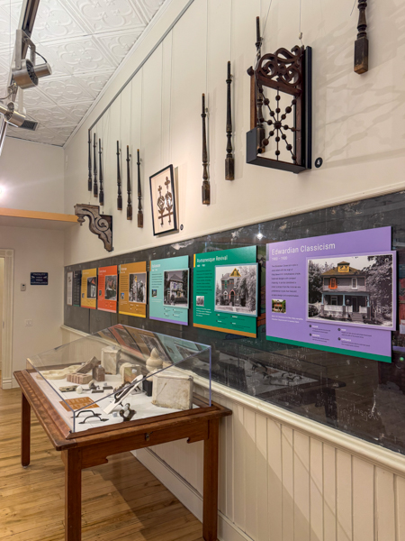 Historical artifacts in a display case and hung on a wall. Educational posters also hung on the wall.