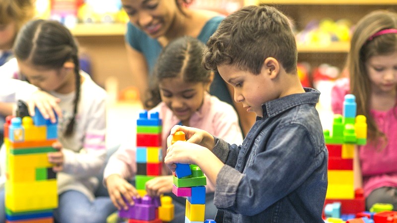 Preschool kids playing with plastic blocks