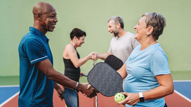 Four adults playing pickleball