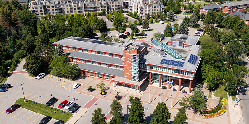 Aerial view of the front of Aurora Town Hall, surrounded by trees and with houses in the background