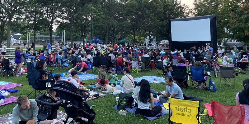 Large outdoor movie screen residents watching movie