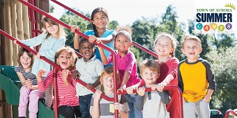 Group of kids on outdoor playground equipment during summer camp