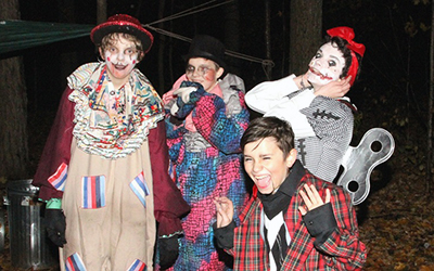 4 children dressed up for Halloween, in a dark night setting