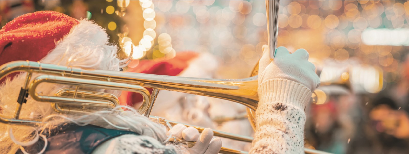 Closeup of someone in a Santa costume playing the trombone