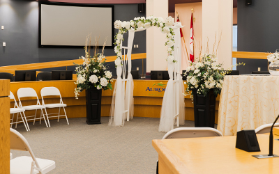 Inside of Council Chambers with wedding arch and flower arrangements