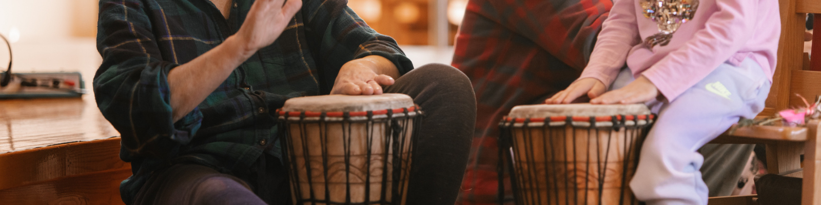 An adult and child's hands playing the drums.