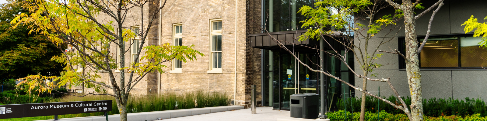 Front door at 50 Victoria Street surrounded by trees and a sign that reads Museum & Cultural Centre