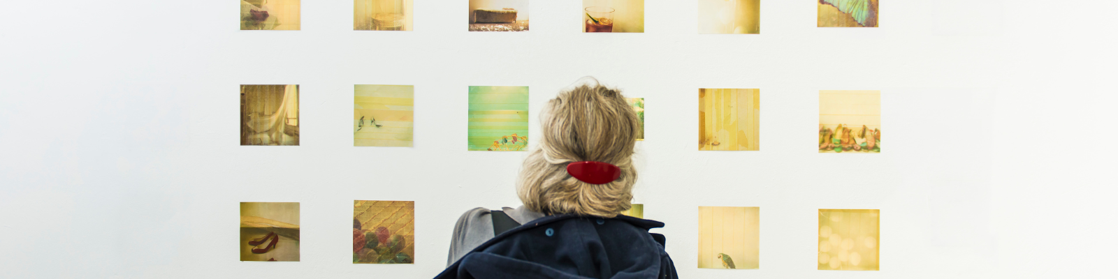 Woman looking at a photography exhibit on a white wall