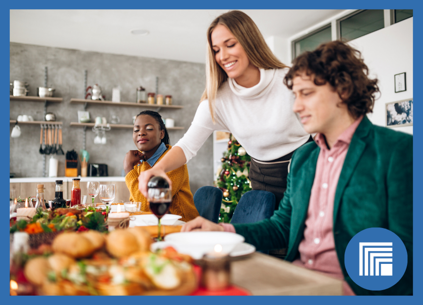 A woman serving her guests at a dining room table during the holidays