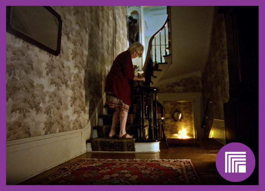 Lady on first step of old home staircase, looking back