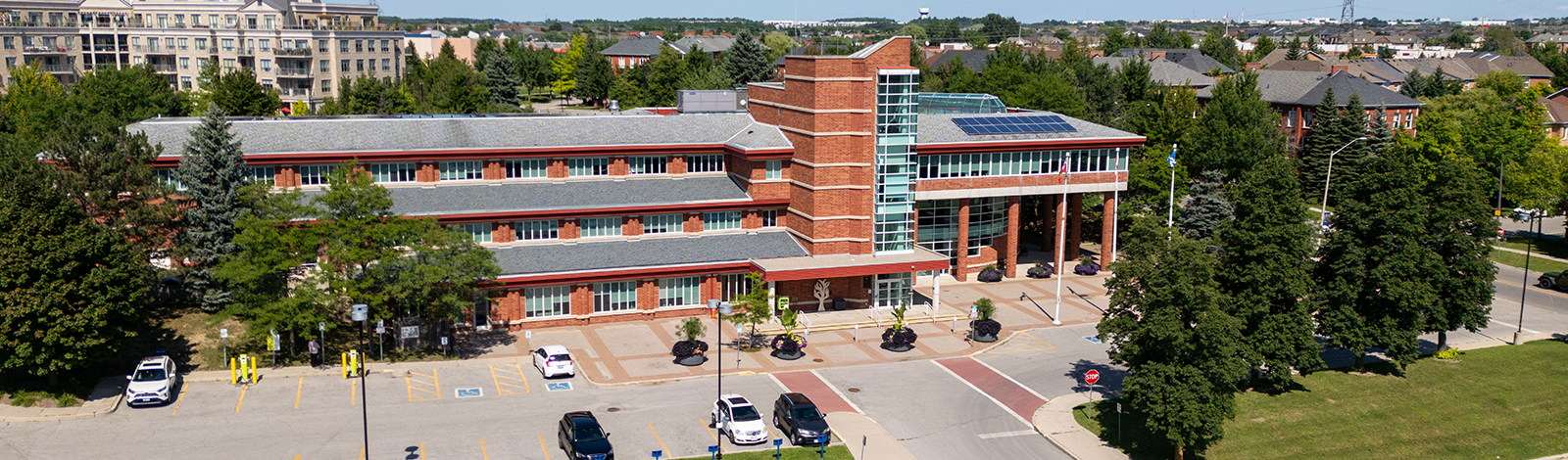 Aerial view of the front of Aurora Town Hall, surrounded by tress and houses behind